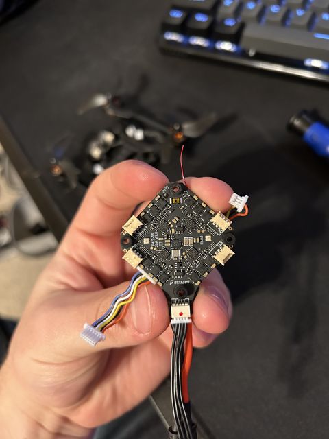 Pavo20 flight controller board held in a hand