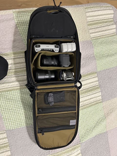 Open camera backpack with the camera, lenses, and drone packed